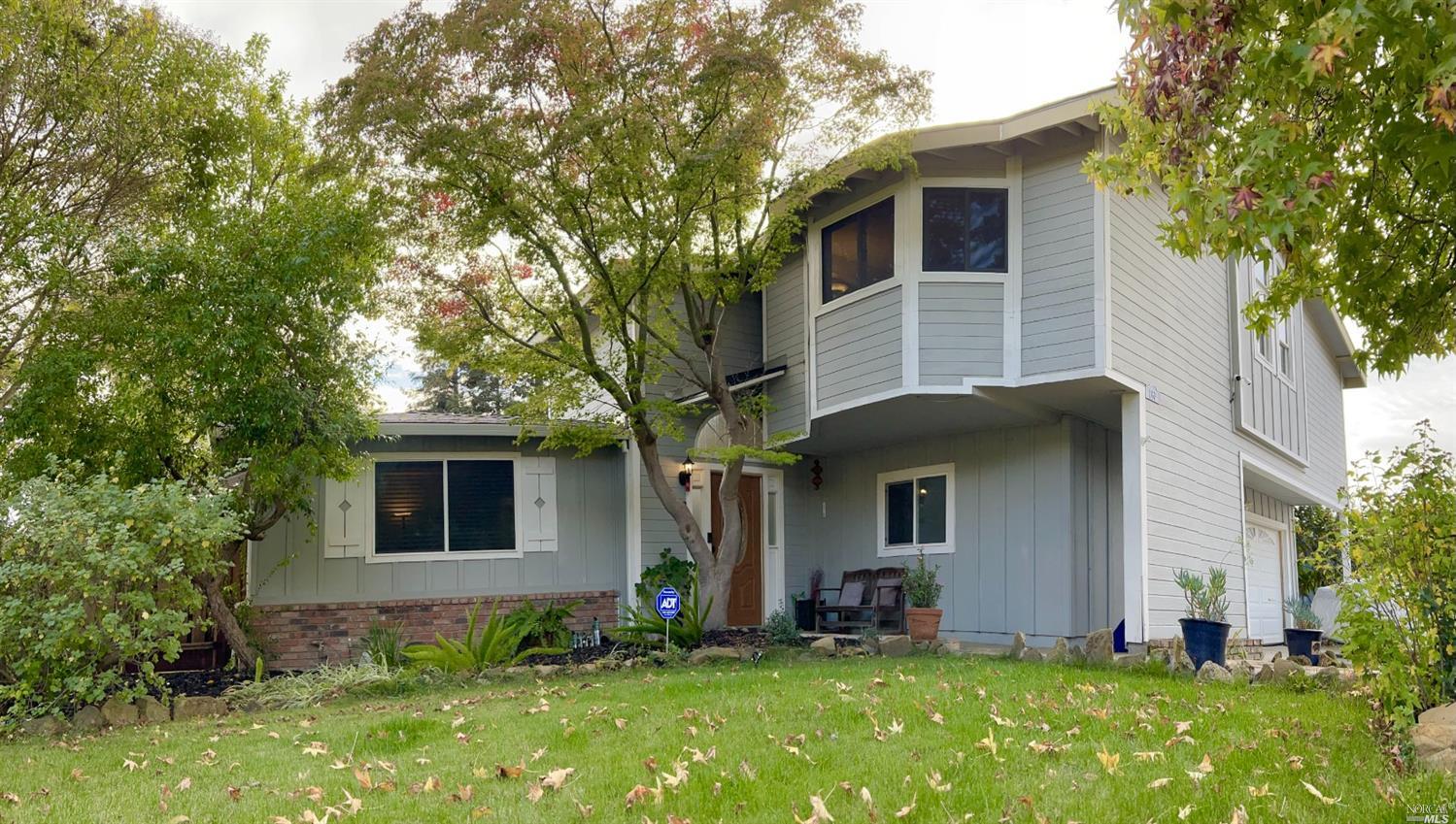 a front view of a house with a yard and trees
