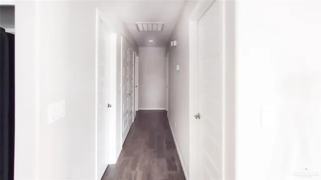 a view of a hallway with wooden floor