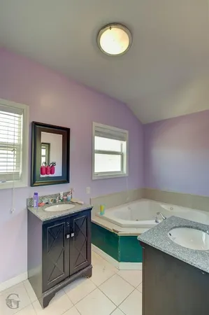 a bathroom with a tub sink and mirror