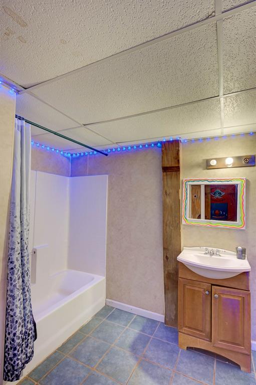 120 Bella Vista Loop Homer, LA 71040 - Photo 19 of 27 Bathroom with a drop ceiling, shower / tub combo, vanity, and dark tile patterned floors