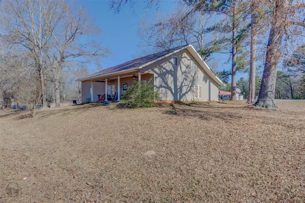 a backyard of a house with large trees and covered with tall trees