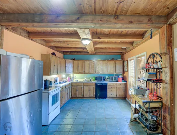 a kitchen with lots of wooden cabinets and stainless steel appliances