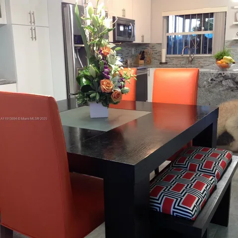 a view of a hallway with wooden floor and a cabinet