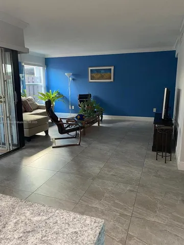 a living room with furniture a rug and a window