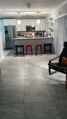 a kitchen with stainless steel appliances granite countertop a table chairs sink and cabinets