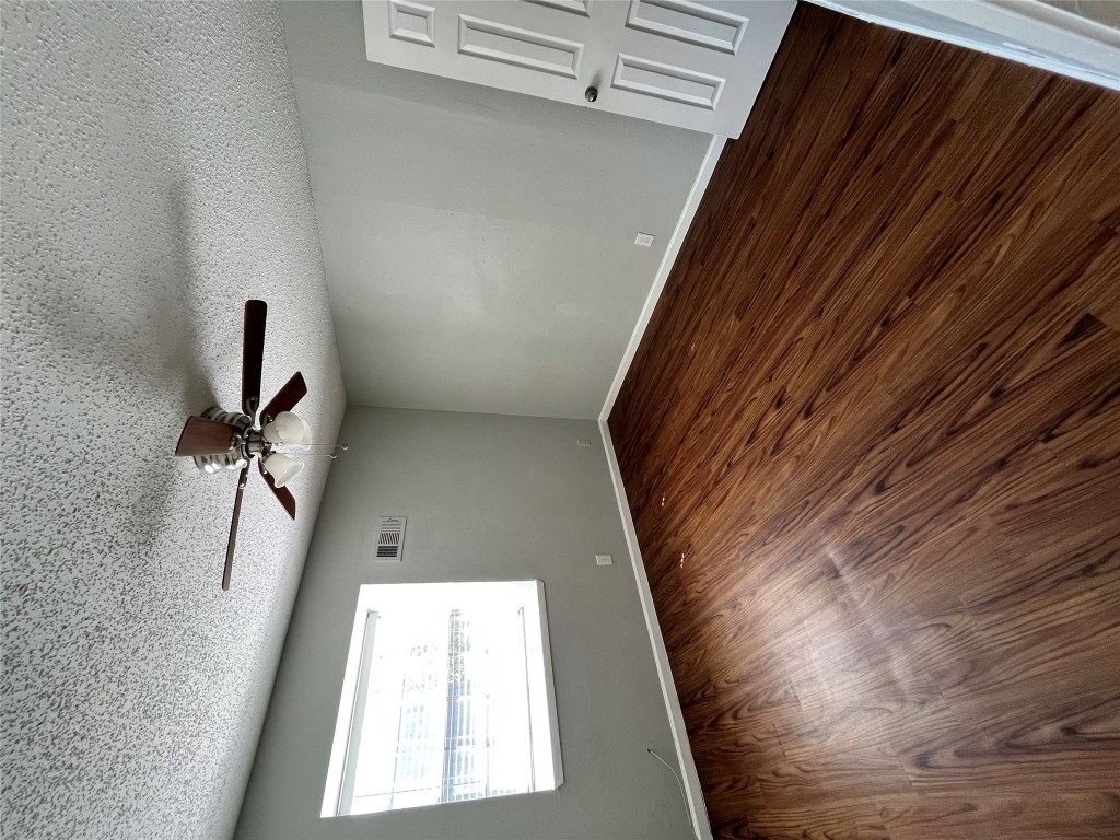 4906 West Gate Boulevard, Unit 104 Austin, TX 78745 - Photo 11 of 22 Unfurnished room with a textured ceiling, dark wood finished floors, and a ceiling fan