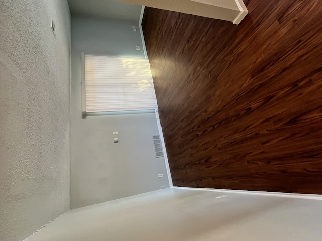 4906 West Gate Boulevard, Unit 104 Austin, TX 78745 - Photo 3 of 22 Spare room featuring a textured ceiling and dark wood-style floors