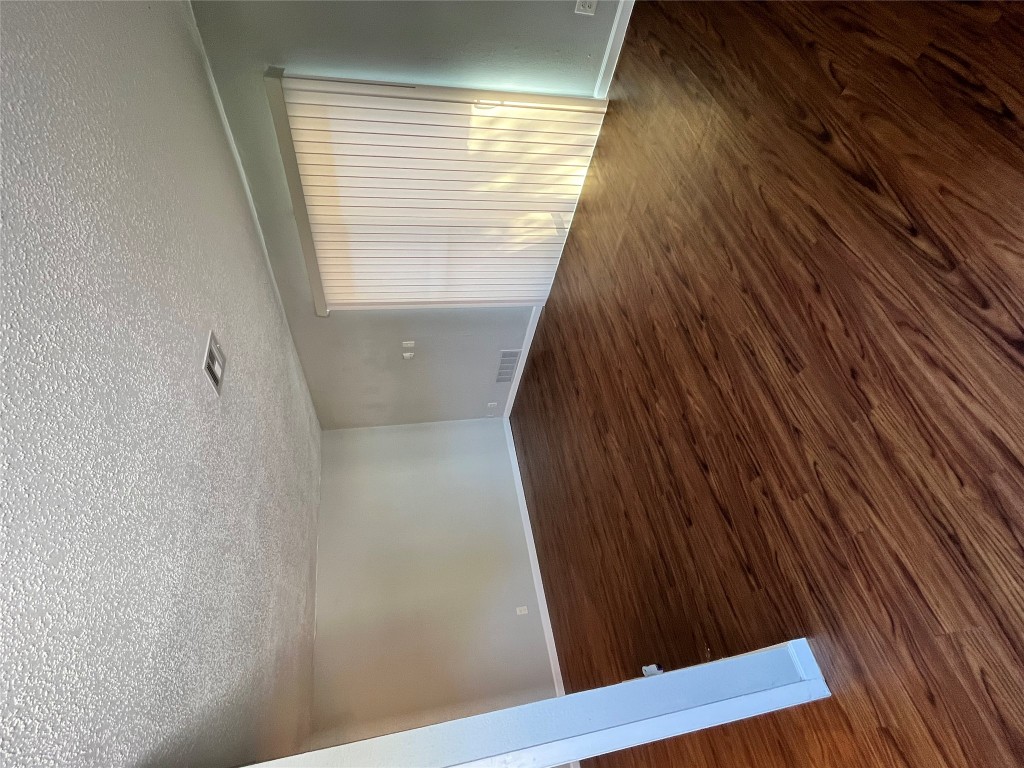 4906 West Gate Boulevard, Unit 104 Austin, TX 78745 - Photo 4 of 22 Empty room featuring dark wood-style floors and a textured ceiling