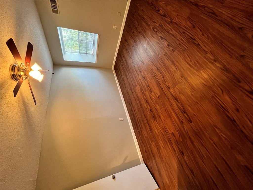 4906 West Gate Boulevard, Unit 104 Austin, TX 78745 - Photo 8 of 22 Unfurnished room featuring dark wood-style floors, a textured ceiling, and ceiling fan