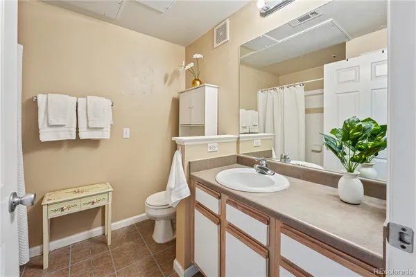 a bathroom with a granite countertop sink a toilet a mirror and shower