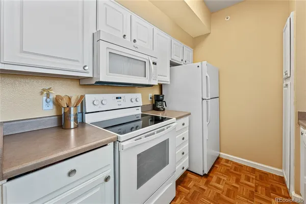 a kitchen with white cabinets and white appliances
