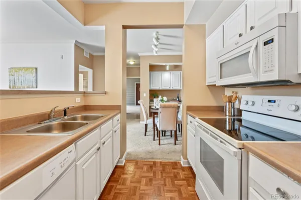 a kitchen with granite countertop a sink and white cabinets