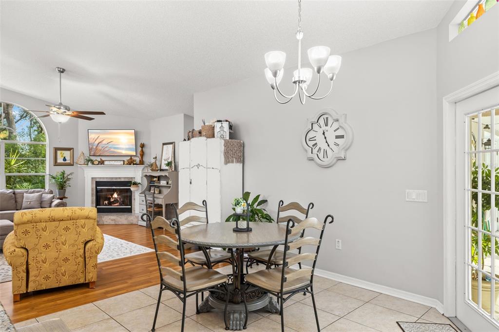 3734 Thornbush Lane New Port Richey, FL 34655 - Photo 16 of 47 a dining room with furniture a fireplace and a chandelier