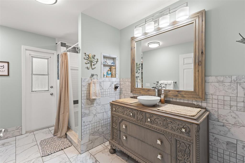 3734 Thornbush Lane New Port Richey, FL 34655 - Photo 28 of 47 a bathroom with a granite countertop sink a mirror and a shower