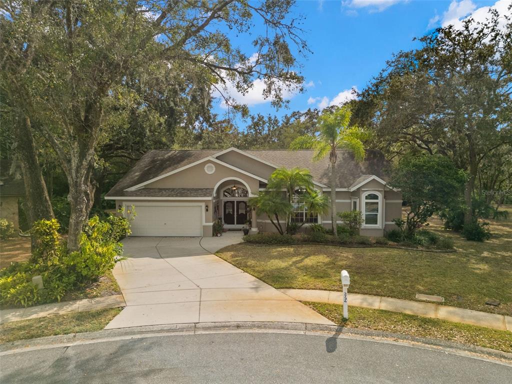 3734 Thornbush Lane New Port Richey, FL 34655 - Photo 39 of 47 a front view of a house with a yard garage and outdoor seating