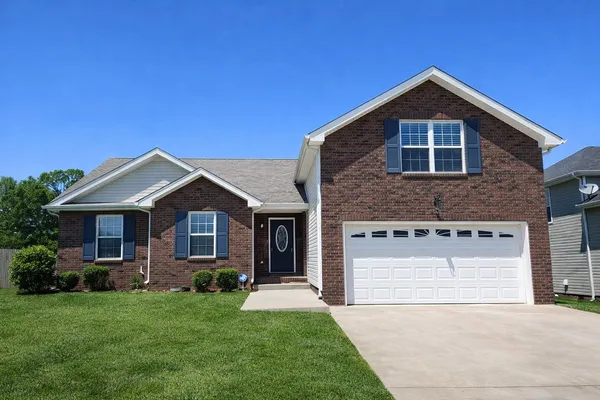 a front view of a house with a yard and garage