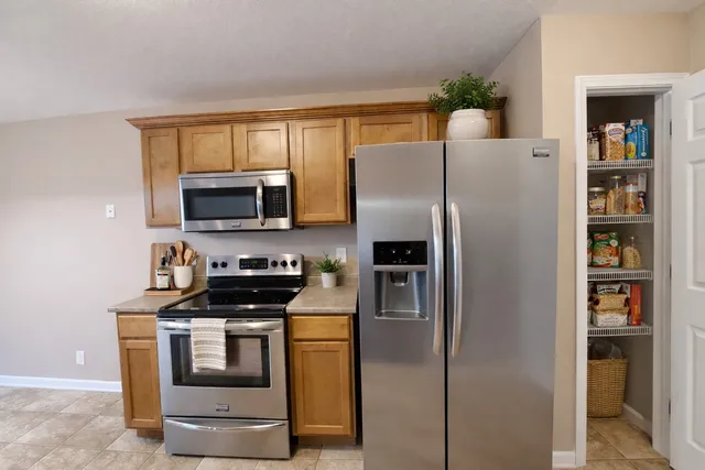 a kitchen with stainless steel appliances a refrigerator stove and microwave