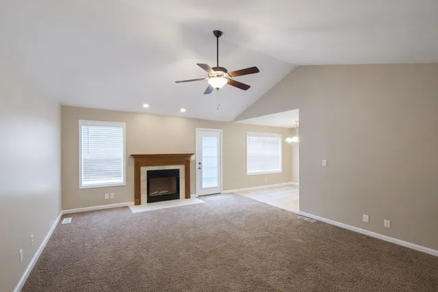 a view of a livingroom with a fireplace and a ceiling fan