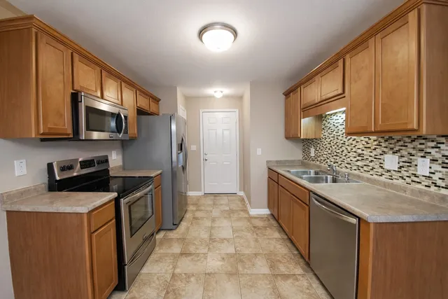 a kitchen with stainless steel appliances granite countertop a sink stove and refrigerator