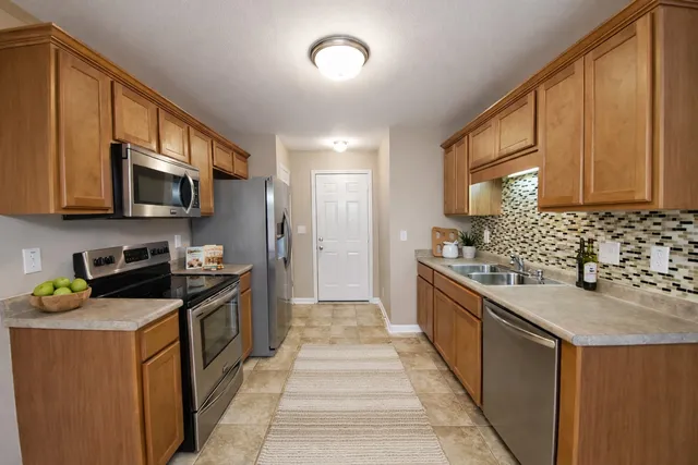 a kitchen with stainless steel appliances granite countertop a sink stove and refrigerator