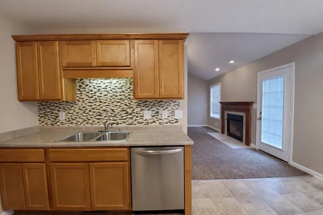 a kitchen with granite countertop a sink cabinets and a wooden floor