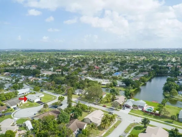 an aerial view of residential houses with outdoor space and lake view