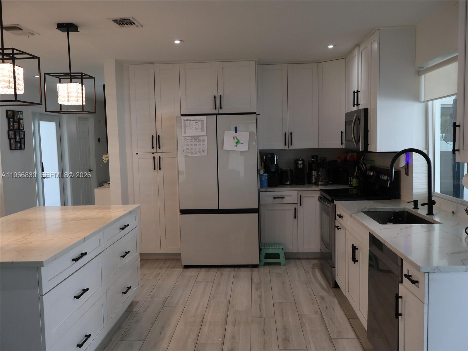 5505 Southwest 9th Street Margate, FL 33068 - Photo 15 of 53 a kitchen with a refrigerator a sink and wooden floor