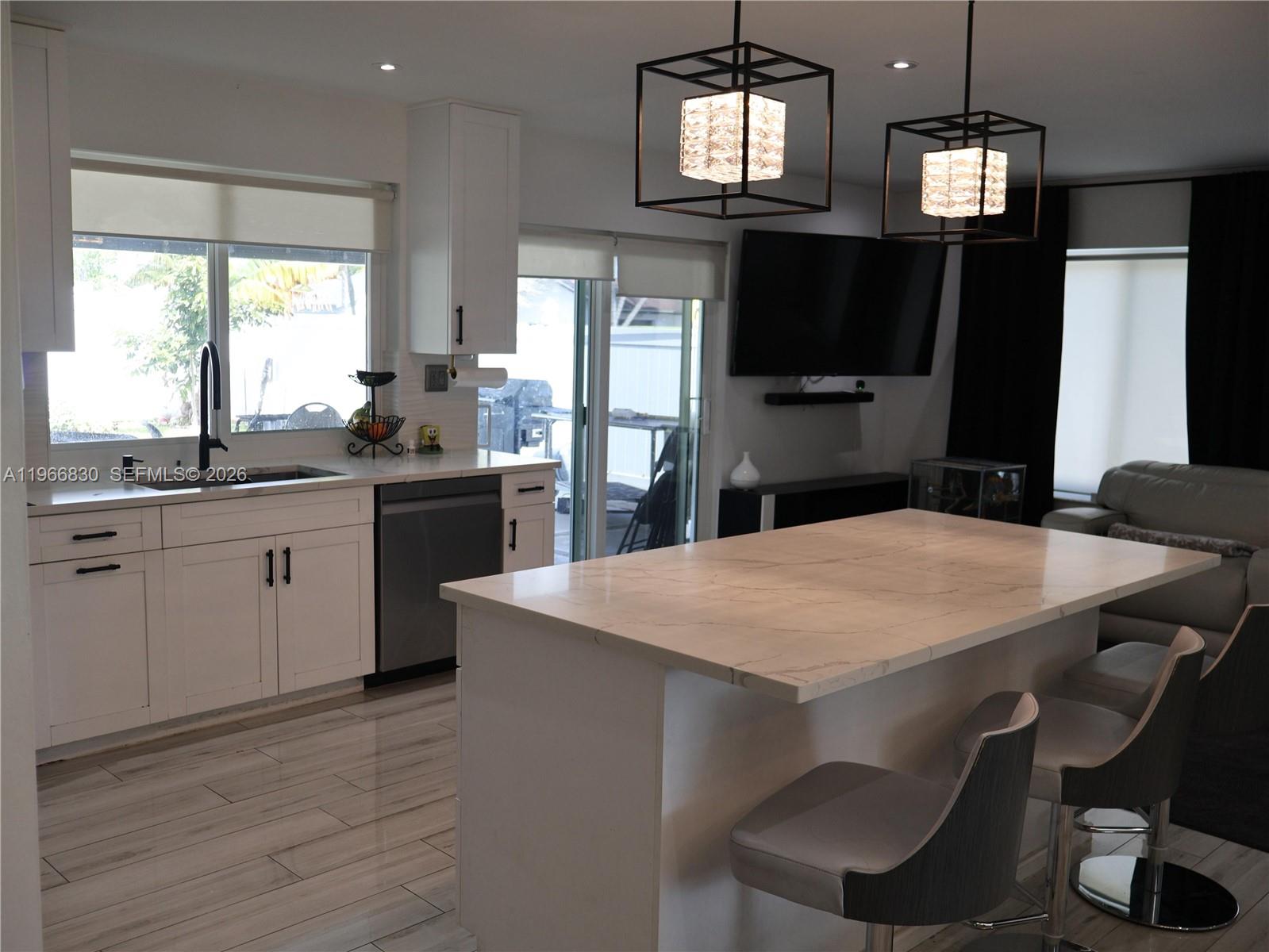 5505 Southwest 9th Street Margate, FL 33068 - Photo 19 of 53 a kitchen with a table chairs refrigerator and microwave