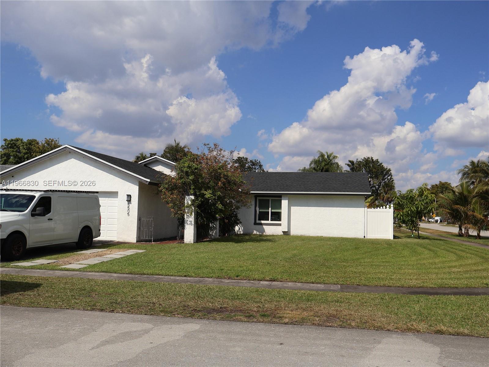 5505 Southwest 9th Street Margate, FL 33068 - Photo 28 of 53 a view of a white house in front of a big yard with large trees