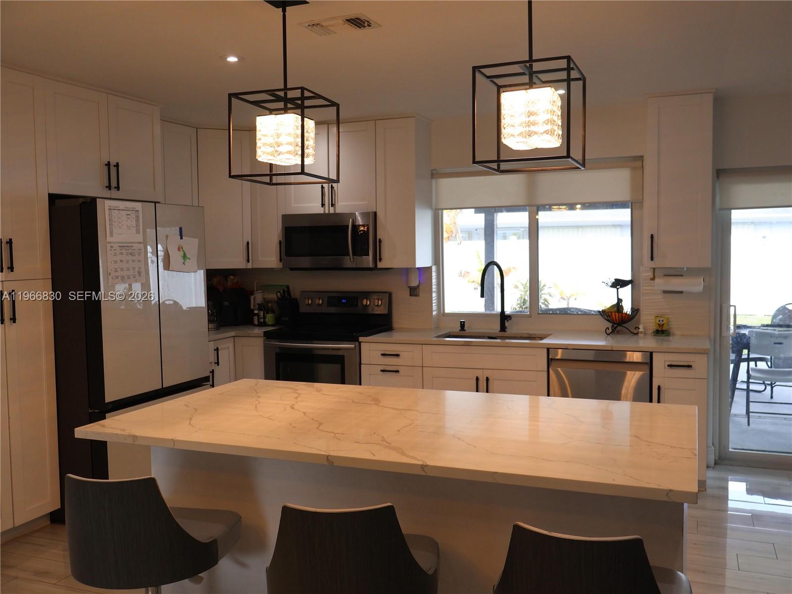 5505 Southwest 9th Street Margate, FL 33068 - Photo 33 of 53 a kitchen with kitchen island a counter space a sink a window and stainless steel appliances