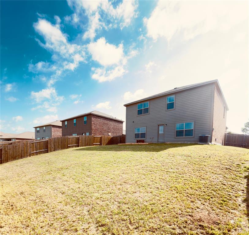 196 Cattlemans Crk Road West Newark, TX 76071 - Photo 18 of 24 Expansive backyard featuring a partial wood fence, a full two-story exterior with horizontal siding, multiple windows, and a ground-level door