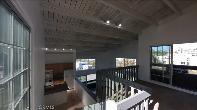 a view of a hallway with wooden floor and stairs