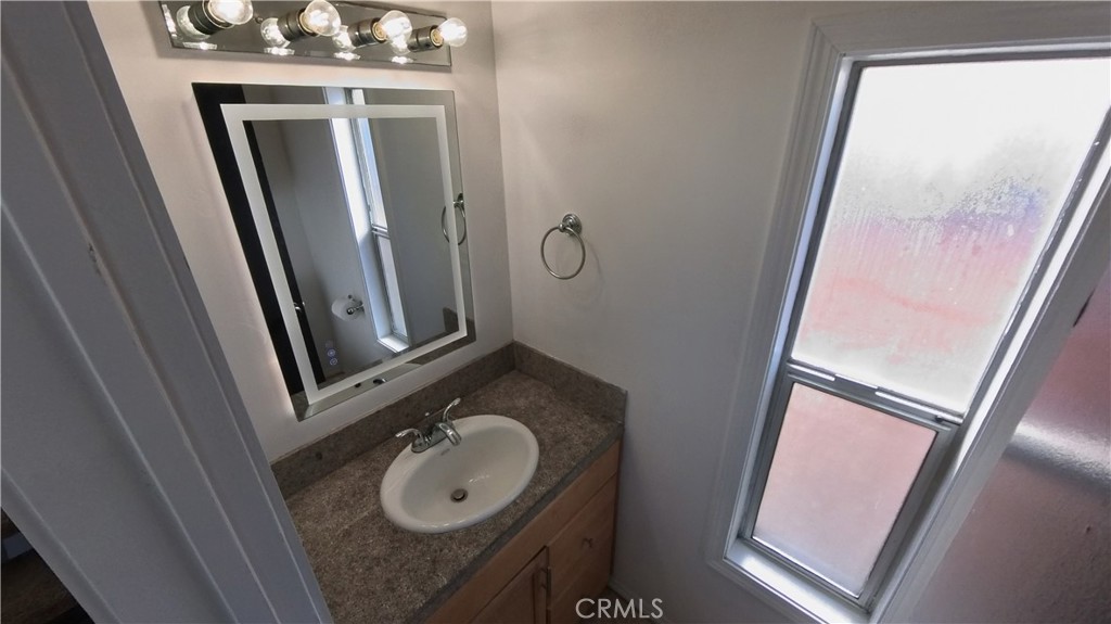 124 Buccaneer Street, Unit 1 Marina del Rey, CA 90292 - Photo 14 of 41 a bathroom with a granite countertop sink and a mirror