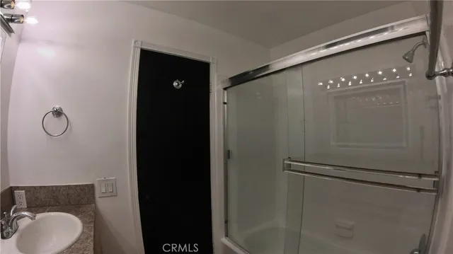 a bathroom with a granite countertop sink and mirror