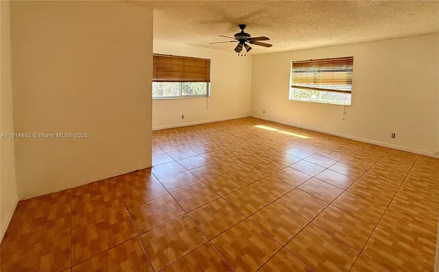 an empty room with closet and a chandelier fan