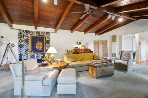 a living room with fireplace furniture and a chandelier