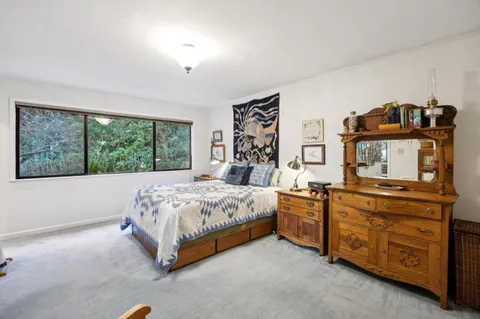 a bed sitting in a bedroom next to a window