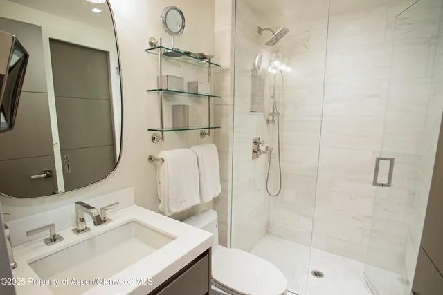 a bathroom with a sink vanity granite toilet and shower