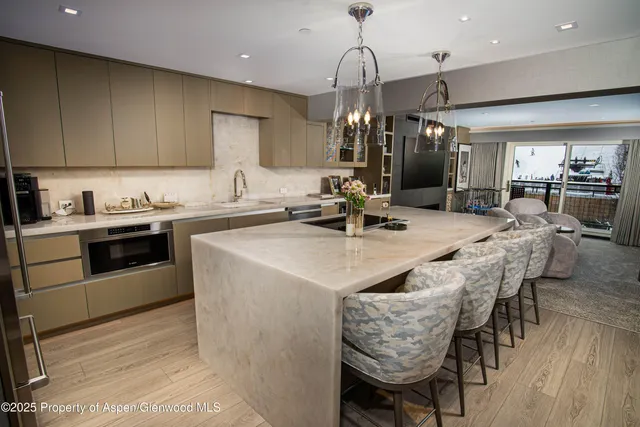 a kitchen with stainless steel appliances granite countertop a sink a stove and a wooden floors