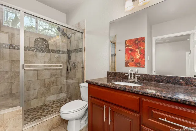 a bathroom with a granite countertop sink toilet and shower