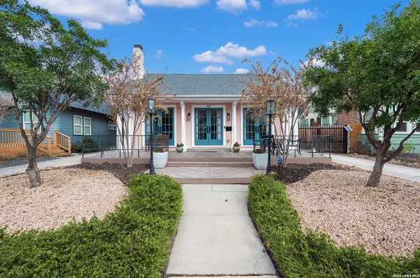 a front view of a house with a yard and potted plants