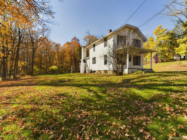 a large house with a big yard and large trees