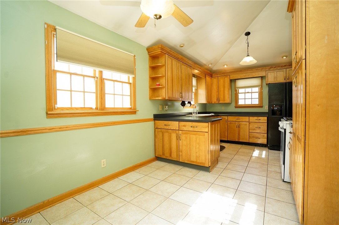 453 Omar Street Struthers, OH 44471 - Photo 14 of 27 Kitchen featuring wood finish cabinetry, lofted ceiling, open shelves, light tile patterned floors, and dark countertops
