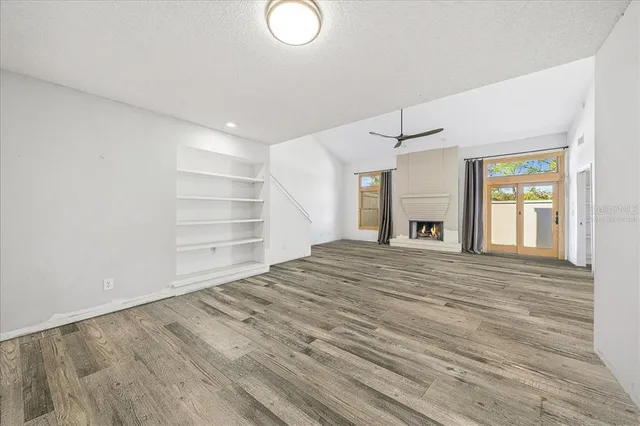 a view of an empty room with window and fireplace