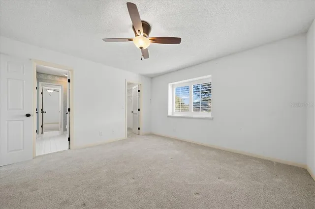an empty room with closet and ceiling fan