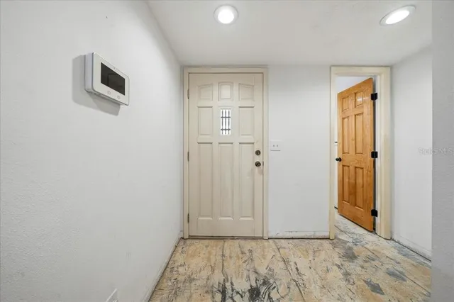a view of a livingroom with wooden floor and a bathroom