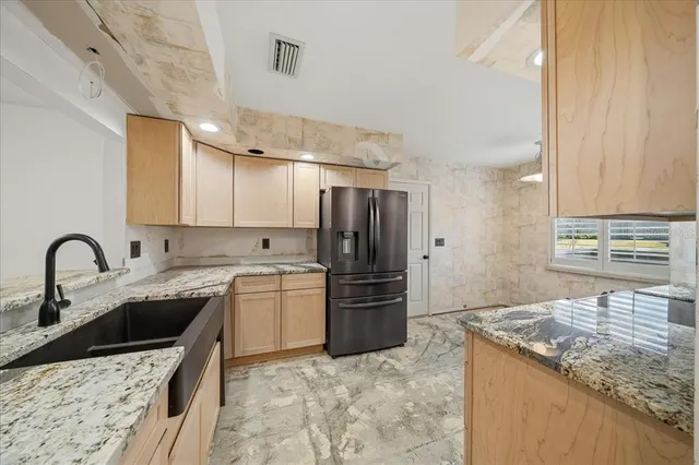 a kitchen with stainless steel appliances granite countertop a sink stove and refrigerator