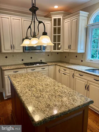 a kitchen with sink a window and cabinets