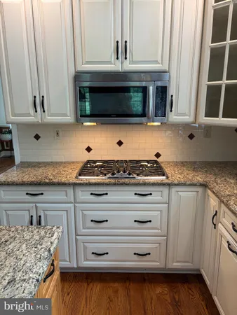a kitchen with granite countertop a stove and a microwave