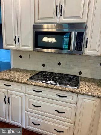 a stove top oven sitting inside of a kitchen
